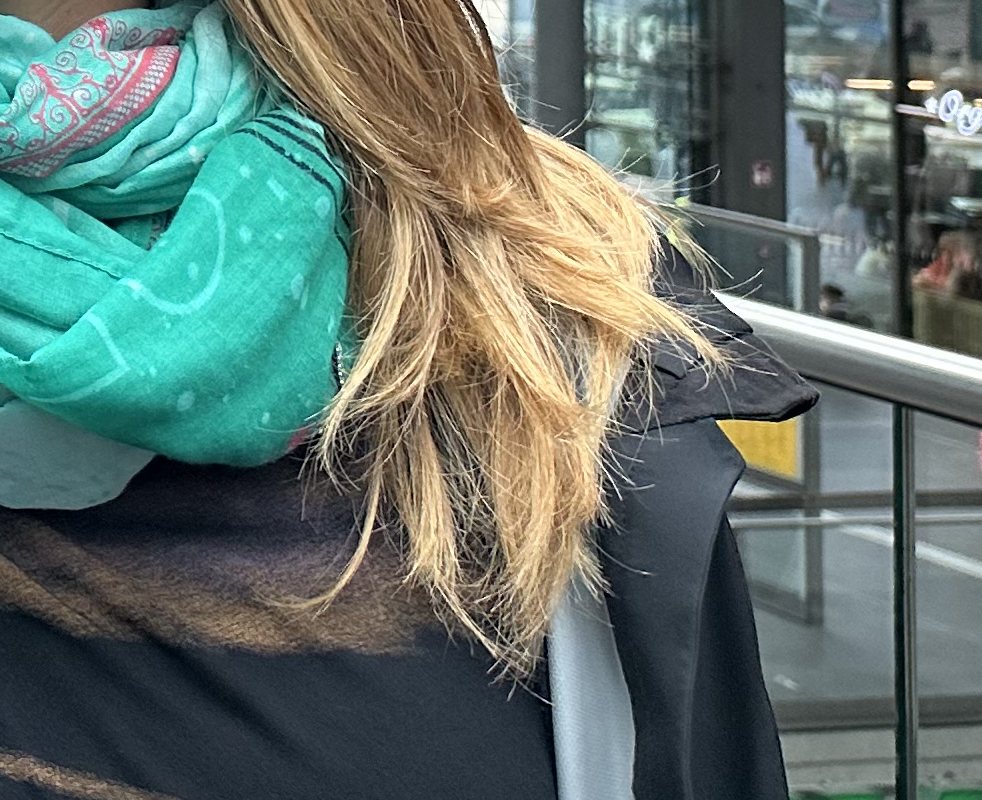 Trockene Haare im Winter: ausgefranste, trockene Spitzen über Schal und Jacke